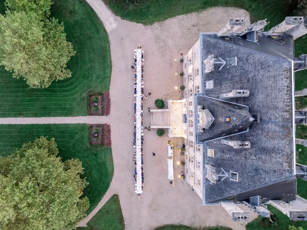 Vue aérienne d'un château en Dordogne avec une réception dressée en extérieur au coucher du soleil